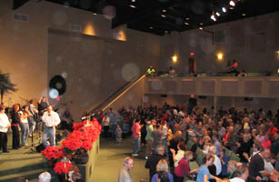 Audience raising their hands beneath an auditorium balcony