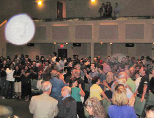 Crowd with a large white circular light spot (angel orbs) in the upper left of the photograph