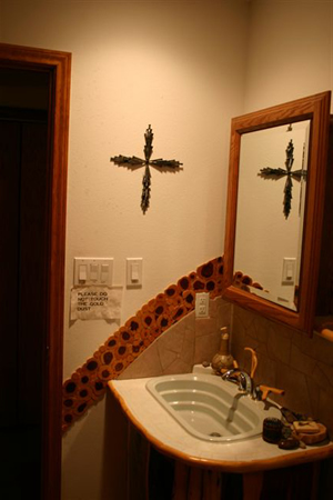 Bathroom vanity and mirror beneath a wall cross